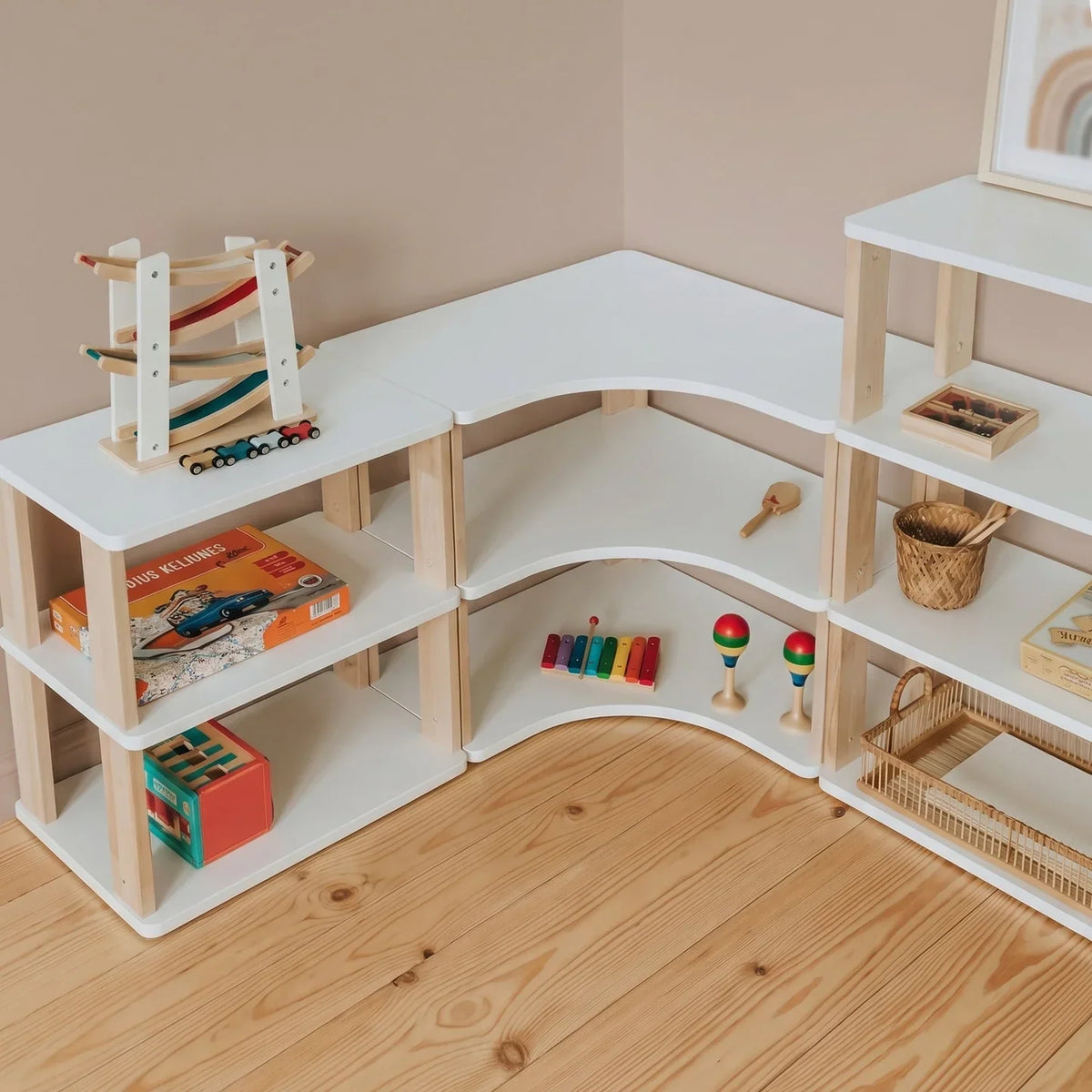 Calm Montessori children's room with low white shelves, corner shelves and an open wardrobe
